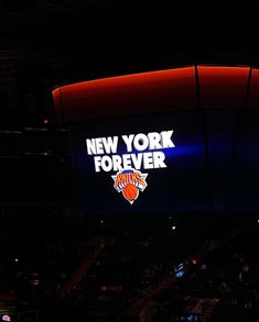 the new york forever logo is lit up at an indoor basketball game as fans watch