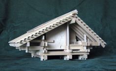 a wooden model of a house made out of wood planks on a green background