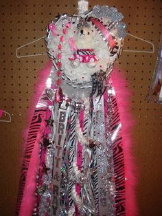 a teddy bear is dressed up in pink and silver