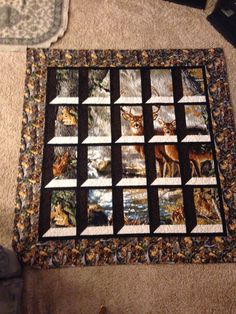 a close up of a quilt on the floor with deers in the woods behind it