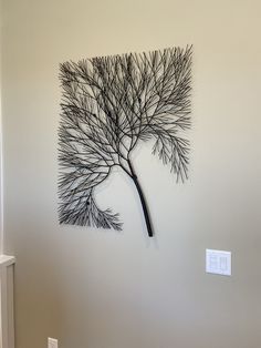 a metal tree is mounted to the wall