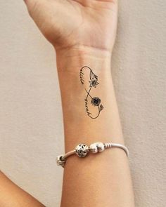 a woman's wrist with a flower tattoo on her left arm and the word love written across it