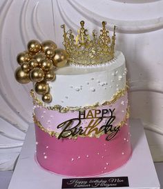 a birthday cake decorated with gold and pink frosting, topped with a tiara