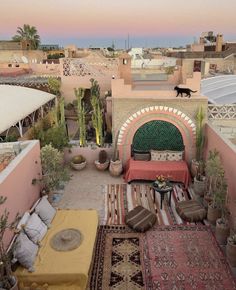 an outdoor patio with lots of seating and rugs