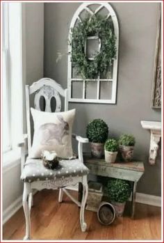 a white chair sitting next to a table with potted plants on top of it