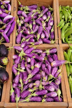 purple and green vegetables are in wooden boxes