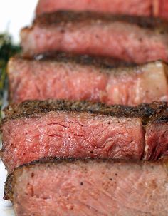 some meat is sitting on a plate with broccoli in the backgroung