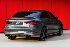 an audi car parked in front of a red wall