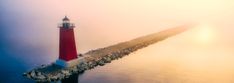 a red and white light house sitting on top of a body of water