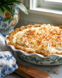 a pie sitting on top of a table next to a potted plant