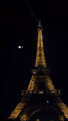 the eiffel tower is lit up at night