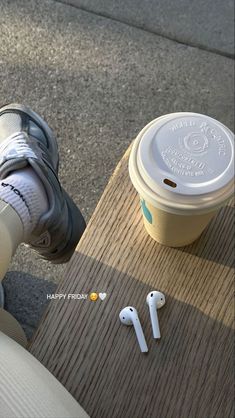 a person sitting on a bench with their feet propped up next to an earbuds