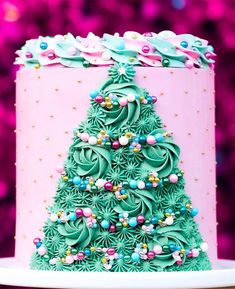 a pink and green christmas tree cake on a plate