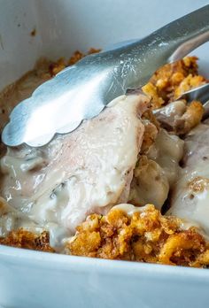 a close up of a spoon in a bowl of food with meat and gravy