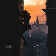 a person climbing up the side of a building with a city in the background at sunset