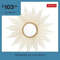 a gold sunburst mirror sitting on top of a table