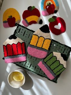 crocheted cupcakes and cake coasters on a table with a bowl of lemonade