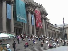 people are sitting on the steps in front of an old building with columns and pillars