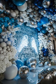 a room filled with blue and white balloons