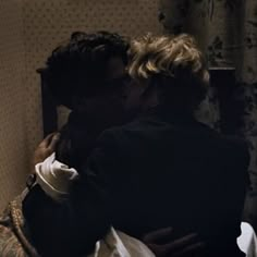 two people are embracing each other in the dark