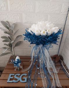 a vase filled with white flowers sitting on top of a wooden table next to a sign that says esg