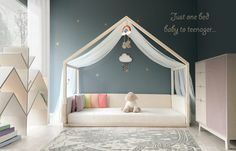 a child's bedroom with a canopy bed and toys on the floor in front of it