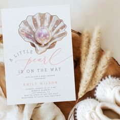 a little pearl is on the way card next to some seashells and shells