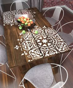 a wooden table with chairs around it and a bowl of fruit on top of it