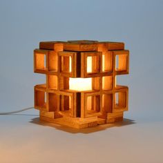 a lamp made out of wooden cubes with a light on the top and bottom