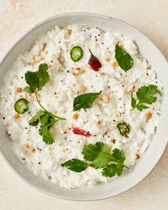 a white bowl filled with rice and garnished with cilantro