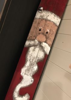 a wooden sign with a santa clause painted on it