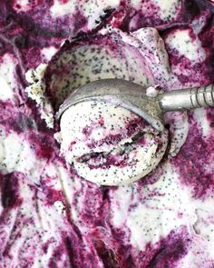 an ice cream scooper sitting on top of a purple and white substance covered surface