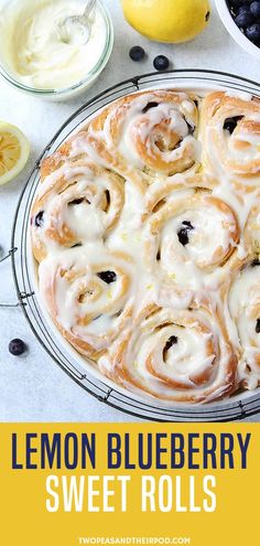 a blueberry lemon roll with icing on a cooling rack next to fresh fruit