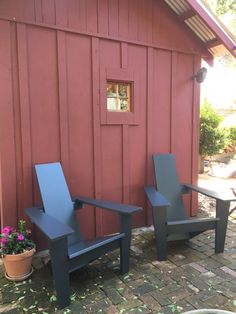 two lawn chairs sitting next to a red building