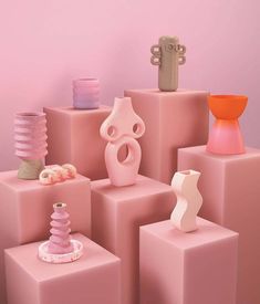 there are many different vases on these pink blocks