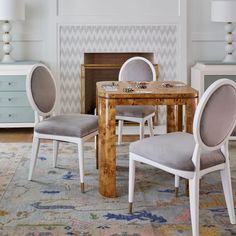 a dining room table with chairs around it and a rug on the floor next to it