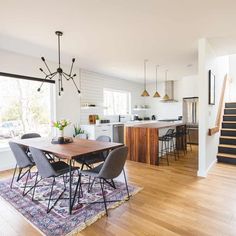 a dining room table with chairs and a rug on the floor in front of it