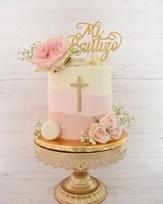 a pink and gold cake with a cross on top