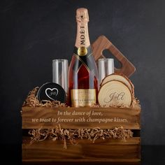 a bottle of wine in a wooden crate with personalized coasters and other items