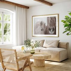 a living room filled with furniture and a painting hanging on the wall over a window