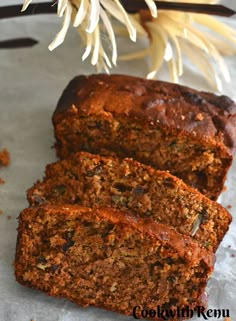 two slices of banana nut bread on a piece of parchment paper next to a flower