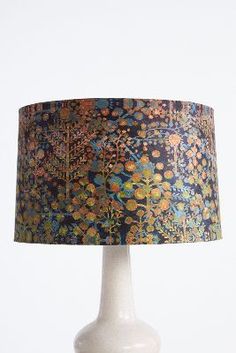 a lamp that is on a table with a blue and orange lampshade over it