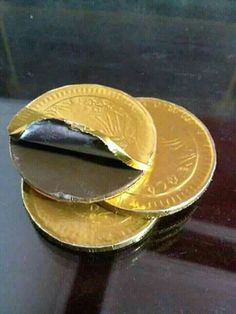 three gold coins sitting on top of each other with one piece missing from the coin