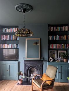 a living room filled with furniture and a fire place in front of a book shelf