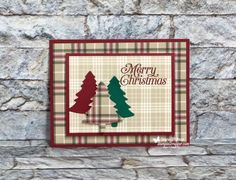 a christmas card on a stone wall with trees in the center and merry christmas written on it