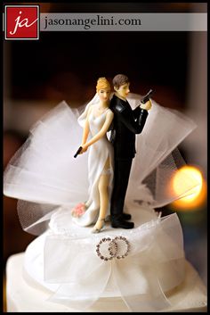 a bride and groom figurine on top of a wedding cake