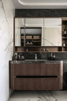 an elegant bathroom with marble counter tops and wooden cabinetry, along with two sinks