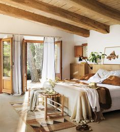 a bed sitting in a bedroom on top of a wooden floor next to a window