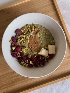 a white bowl filled with food on top of a wooden tray