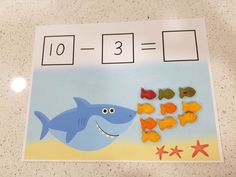 a shark and fish counting game on a table